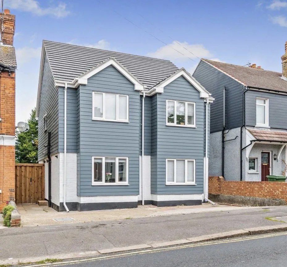 Modern two-storey extension in blue-grey cladding and white render, part of a bungalow-to-town-house conversion in Maidstone