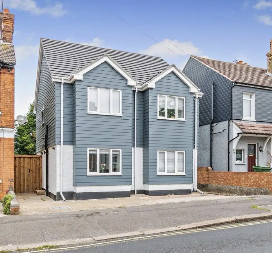 Modern two-storey extension in blue-grey cladding and white render, part of a bungalow-to-town-house conversion in Maidstone