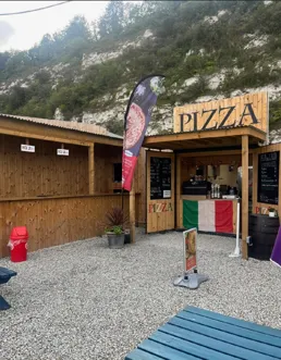 Timber-clad shipping container converted into a pizza shack kiosk with a serving counter and signage